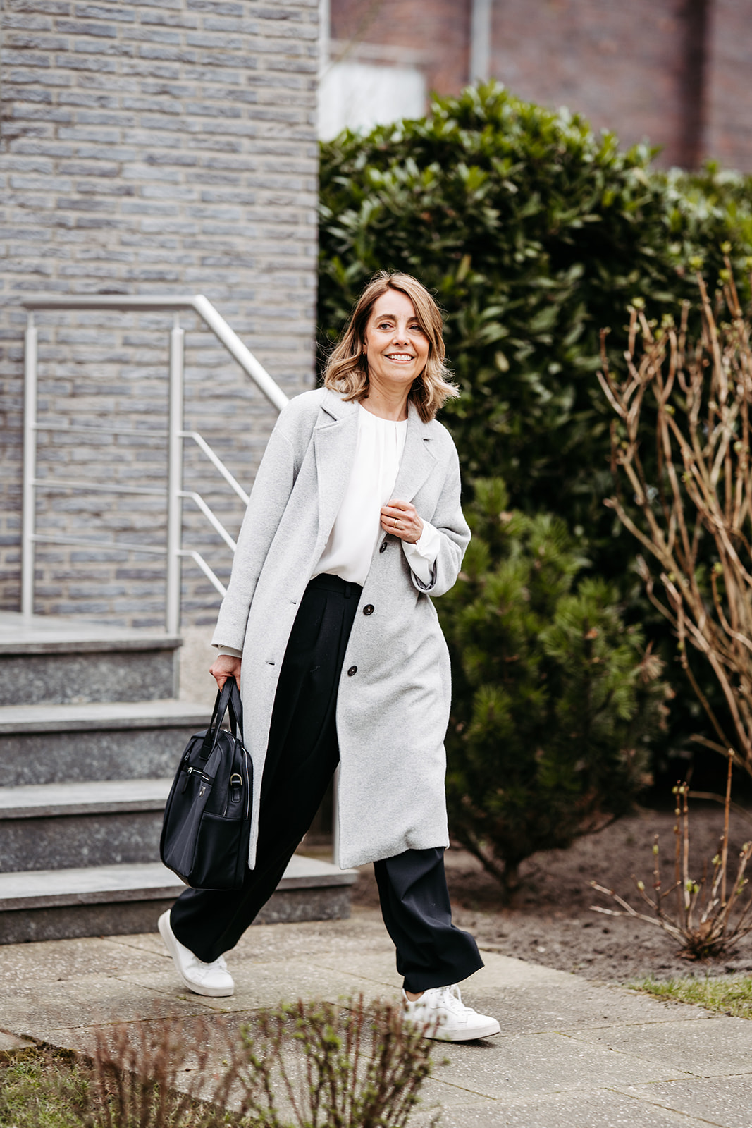 Frau im Mantel und mit Handtasche dynamisch